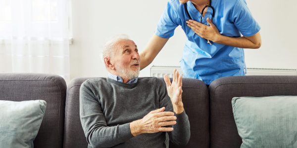 Doctor or nurse caregiver's hand giving support to a senior man at home or nursing home